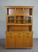 A modern light oak veneered china cabinet, with glass fronted cabinets and niches over a base with