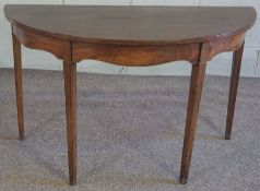A George III style mahogany demi-lune console table, with a plain top and set on four tapered