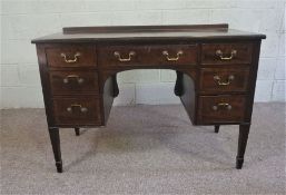 A George III style dressing table, with seven drawers and tapered legs, 78cm high, 115cm wide;