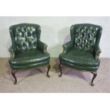 A pair of George III style green leather wing armchairs, 20th century, of compact form, with