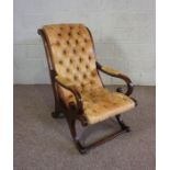 A Regency style mahogany and leather Library bergere armchair, ,with a scrolled back, leather button