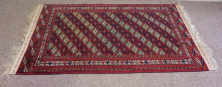 A modern Afghan style rug, decorated with multiple geometric motifs in a grid pattern on red ground,