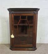 A George III style hanging corner cabinet, with single glazed door opening to shelves