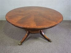 A reproduction Regency extending dining table, late 20th century, with a circular veneered top and