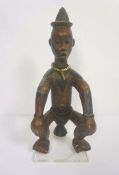 An interesting African tribal carved seated figure, carved naturalistically with light polychromatic