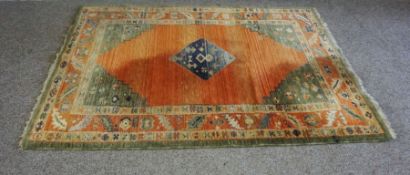 A modern Caucasian style rug, with central lozenge on orange ground, 183cm by 140cm; together with a