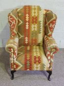 A tapestry covered wing armchair, 116cm high