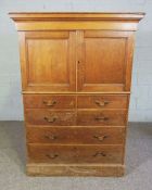 A small pine linen press, circa 1900, with a moulded cornice over two panelled doors, with an