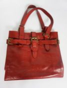 A vintage Mulberry red leather hand bag or tote, with strap handles and brass buckles, stamped
