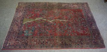 An Isfahan 'Tree of Life' wool rug, decorated with a large central tree on a red ground, within