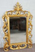 A large modern George III style gilt framed wall mirror, with ornate scrolled frame, 155cm high,