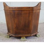 A Regency style mahogany waste paper bin, with hexagonal sides, and four brass paw feet, 34cm high