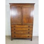 A 19th century mahogany linen press, with moulded cornice over two panelled doors, opening to