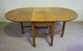 An early 20th century Arts & Crafts oak gate-leg table, with a plain oval drop leaf top on square