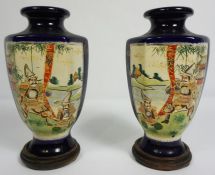 A pair of Japanese export baluster vases, circa 1900, decorated with panels with figures on a blue