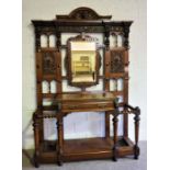 A large Victorian oak Jacobean hall stand, signed Maple & Co., the back with a central mirror