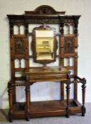 A large Victorian oak Jacobean hall stand, signed Maple & Co., the back with a central mirror