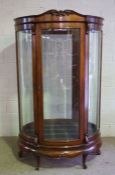 A large mahogany oval free standing shop display cabinet, circa 1900, with six bowed and bevelled