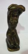 A modern bronzed composition stone sculpture of kneeling nude, with arms wrapped overhead, 50cm