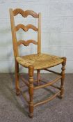 A set of four ash framed ladder back dining chairs, 19th century, with rush seats, each with an