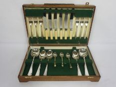 An Art Deco style case of silver plated flatware, for six place settings, with bone handled