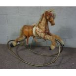 A small vintage child’s Rocking Horse, with tubular frame and saddle, 83cm high, 100cm long