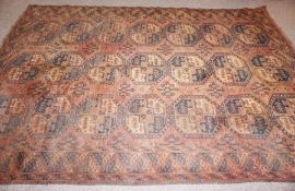 A Turkmen Tekke rug, early 20th century, decorated with three lines of guls on a brown ground within