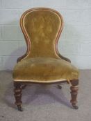 A Victorian mahogany framed spoon-backed nursing chair, circa 1860, currently upholstered in dark