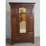 An Edwardian walnut single wardrobe, with an arched mirrored door and single drawers, 198cm high,