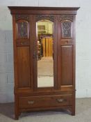 An Edwardian walnut single wardrobe, with an arched mirrored door and single drawers, 198cm high,