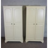 A pair of modern white painted wardrobes, each with two panelled doors, 187cm high, 85cm wide