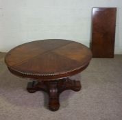 A large George IV style expanding dining table, 20th century, with a circular top set on a central