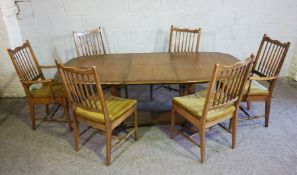 A modern extending dining table with baluster legs, and a set of six spindle backed dining chairs (