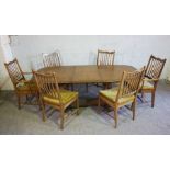 A modern extending dining table with baluster legs, and a set of six spindle backed dining chairs (