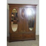 An Edwardian double wardrobe, with two oval mirrored doors and decorative stringing, 203cm high,