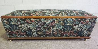 A large upholstered ottoman, with padded floral upholstered top, of sarcophagus form, 43cm high,