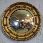 A Regency style circular convex composition gilt framed wall mirror, with ebonized inner moulding,