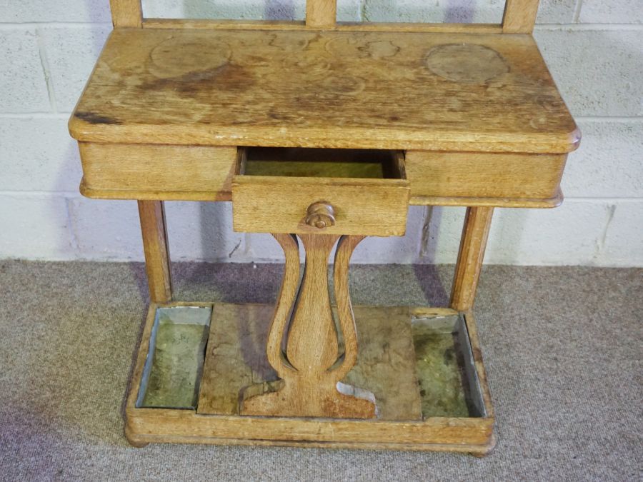 A late Victorian oak hall stand, circa 1900, with an arched top, with nine hat hooks over a small - Image 2 of 4