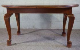 A large oak framed extending dining table, with single leaf, on cabriole legs, 76cm high, 194cm long