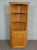 A modern Ercol ash corner cabinet, floor-standing, with two shelves and cabinet, Ercol label,