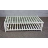 A large modern white coffee table, with lattice magazine under tier and glass top, 43cm high,