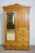 An Edwardian small compactum wardrobe, with a mirrored door offset with a linen cupboard and four