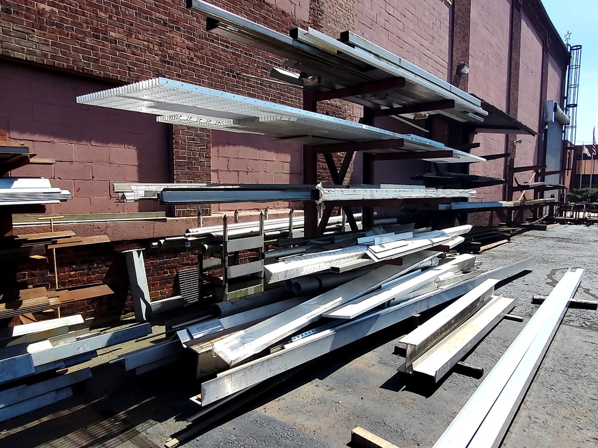 A Group of Ass't Size Steel Grates, Angle Iron, H-Beams, Tubes, Etc. On and Behind Rack