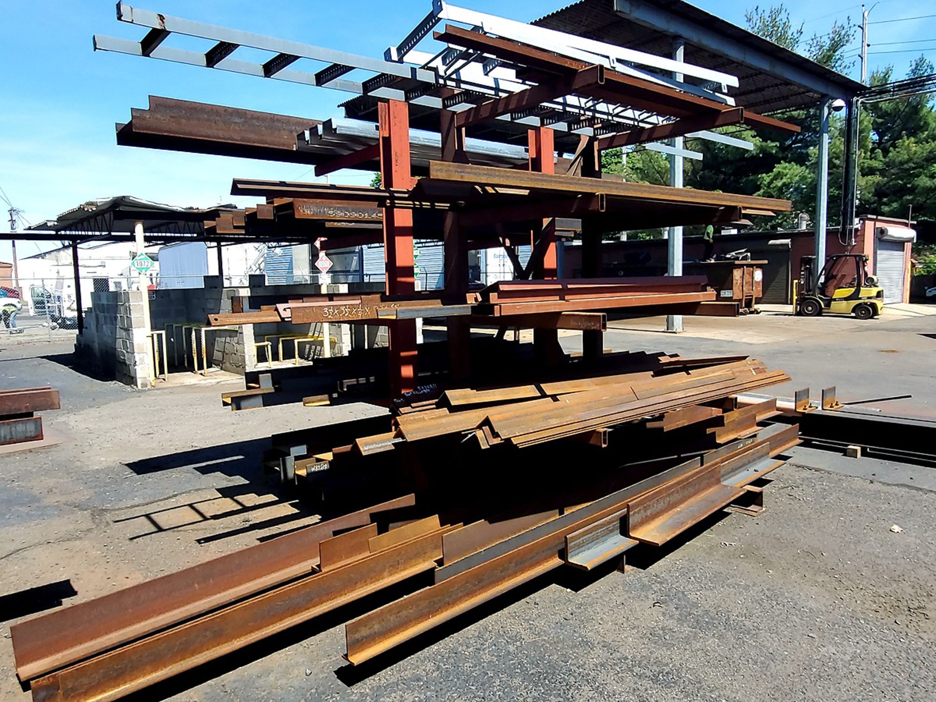 A Group of Ass't Size Steel Angle Iron, U-Channel Beams, T Beams, and Mountable Ladders on Rack