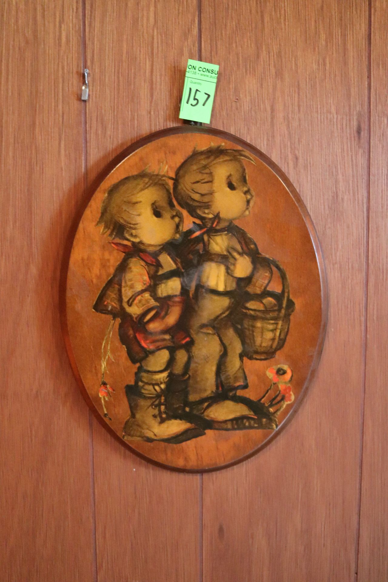 Oval wood artwork picturing two toddlers