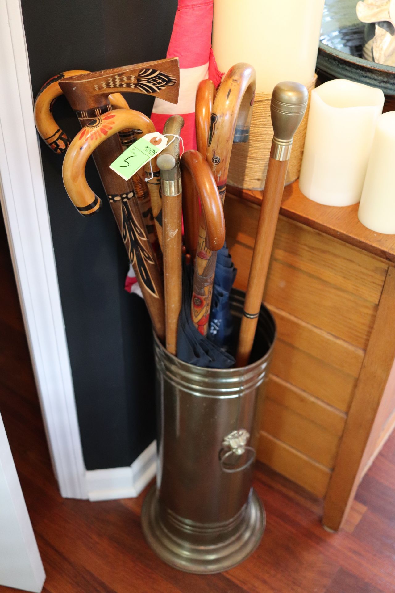 Brass cane stand fitted with lion head and ring handles, with umbrellas and canes, approximate heigh