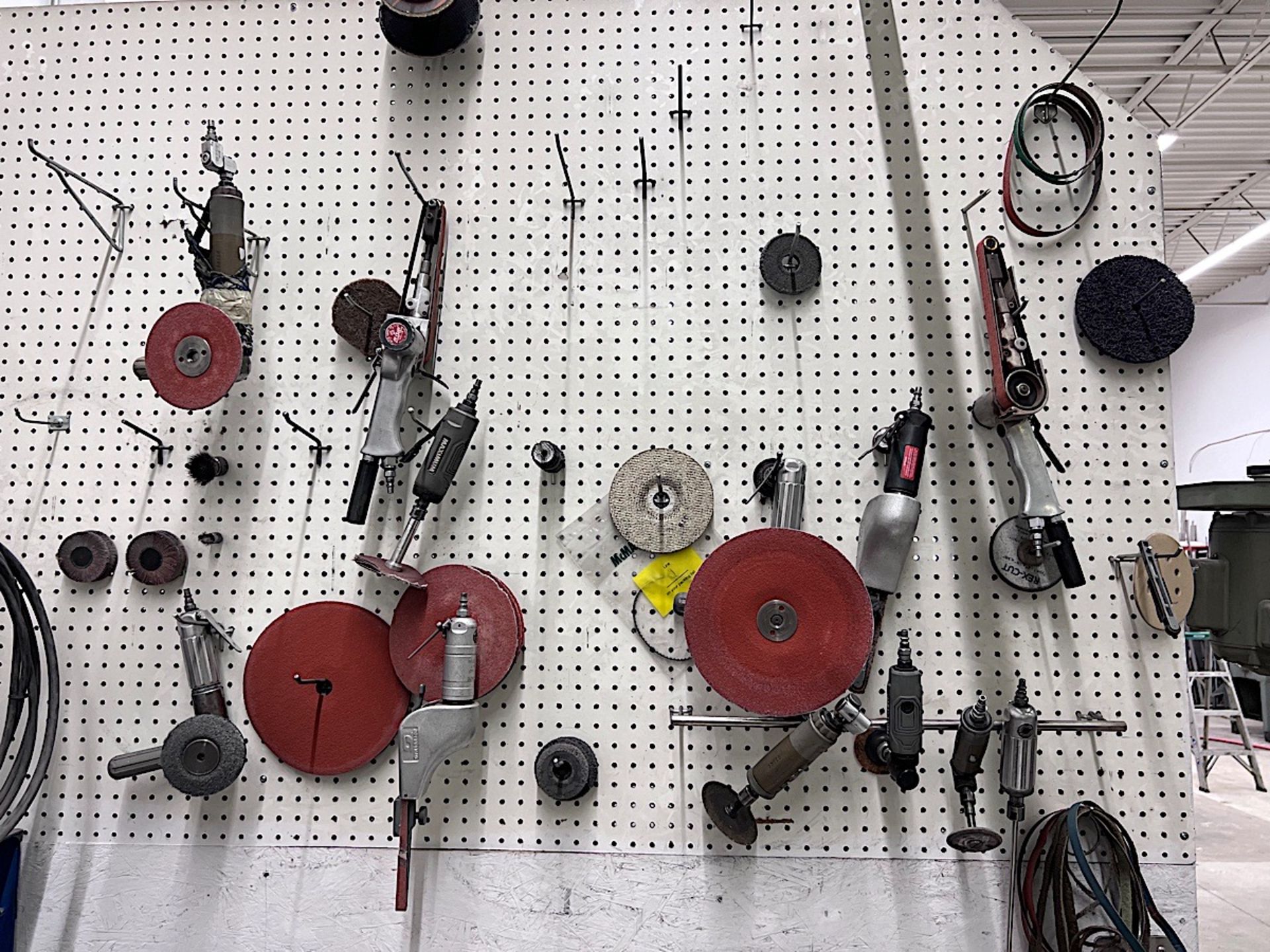 LOT OF PNEUMATIC TOOLS ON WALL