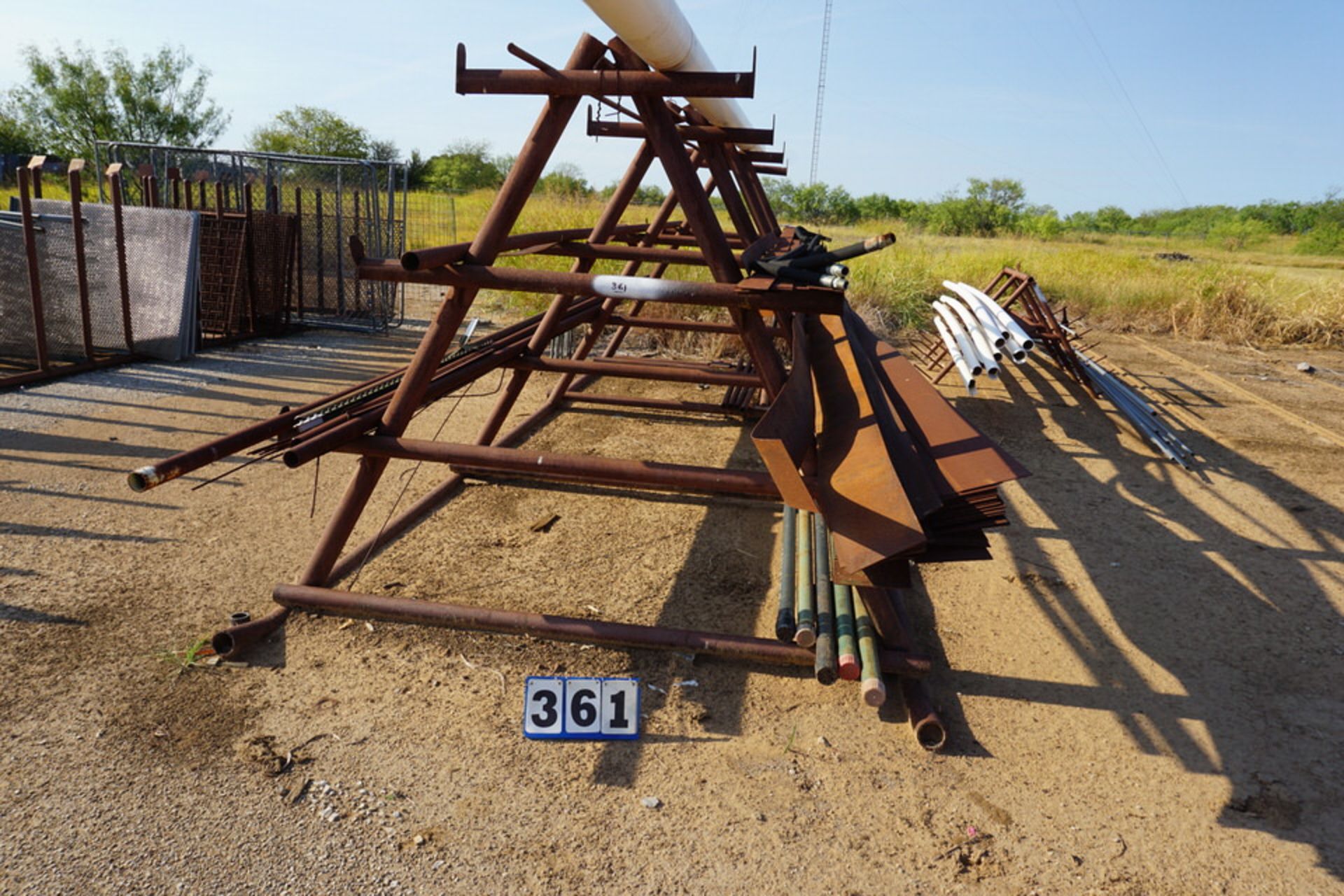 A FRAME MATERIAL RACK APPROX 6'W X 6' TALL W/ ASSORT PIPE & FLAT STOCK