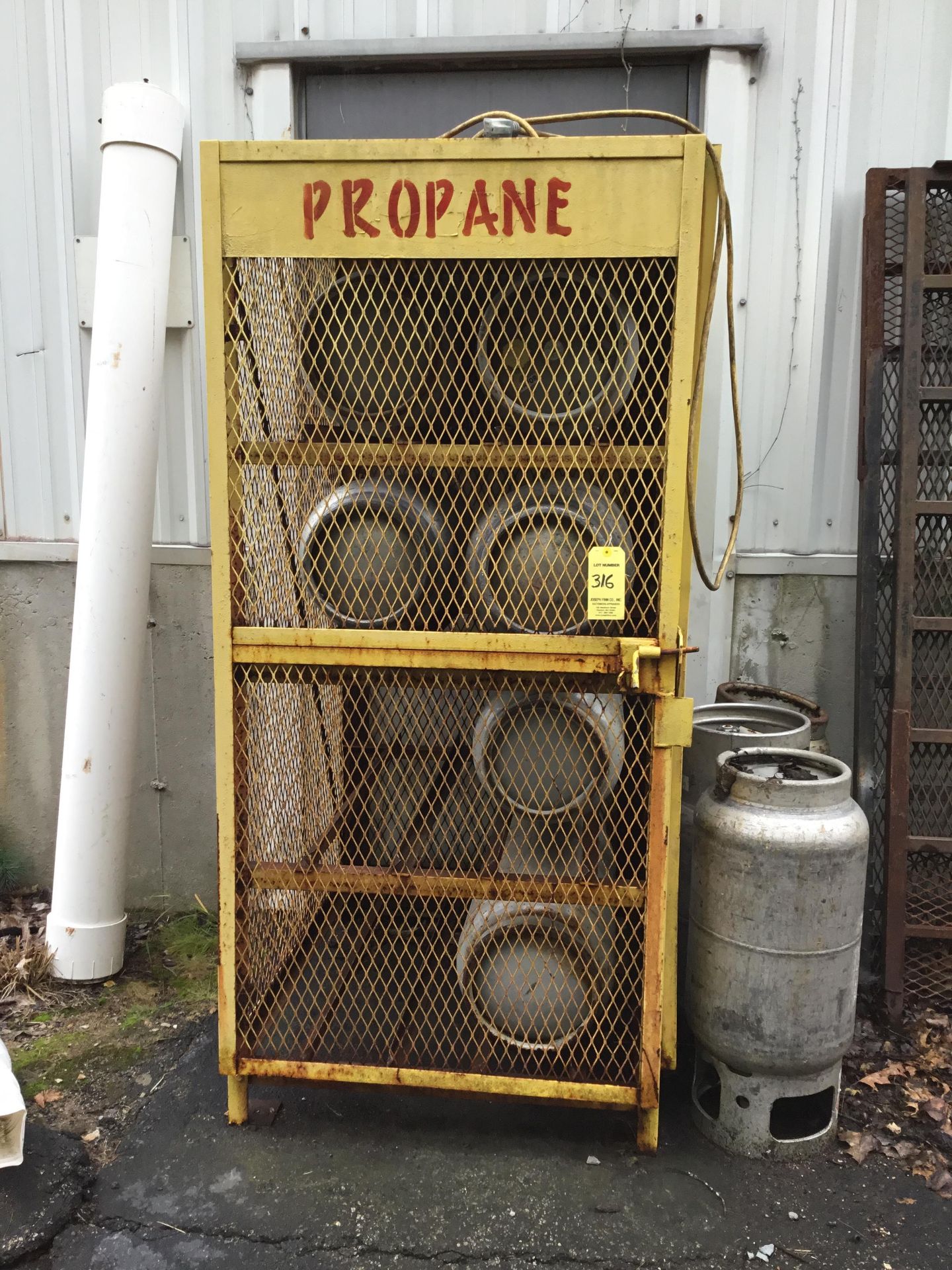 Approximately 8 propane tanks and storage cage