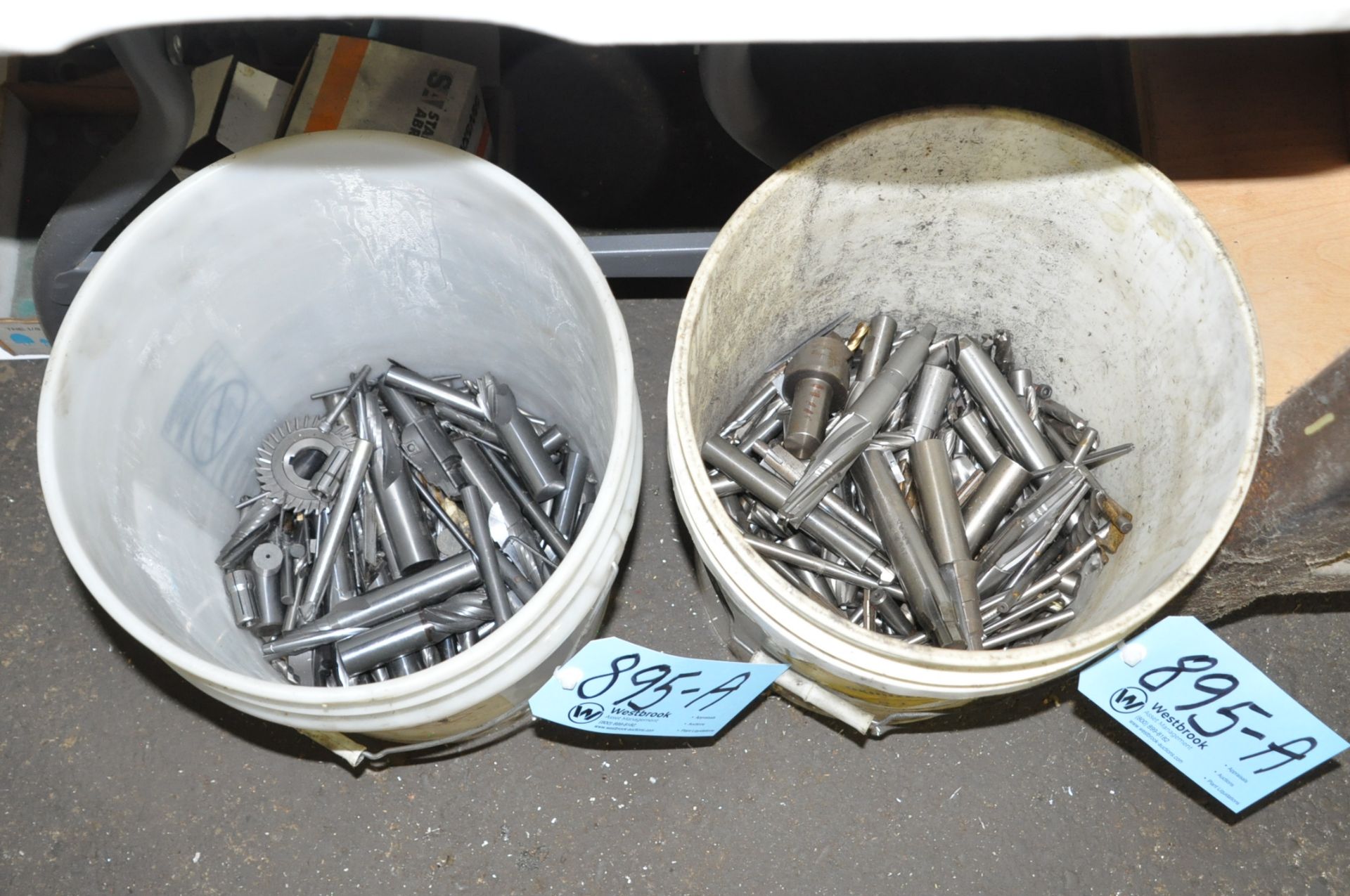 Lot-Various End Mills and Cutters in (2) Pails on Floor Under (1) Table